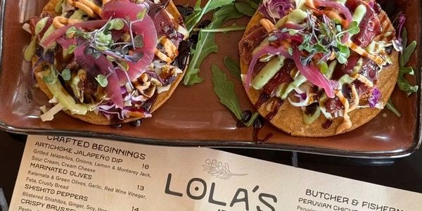Two flavorful tostadas topped with fresh vegetables and sauces.