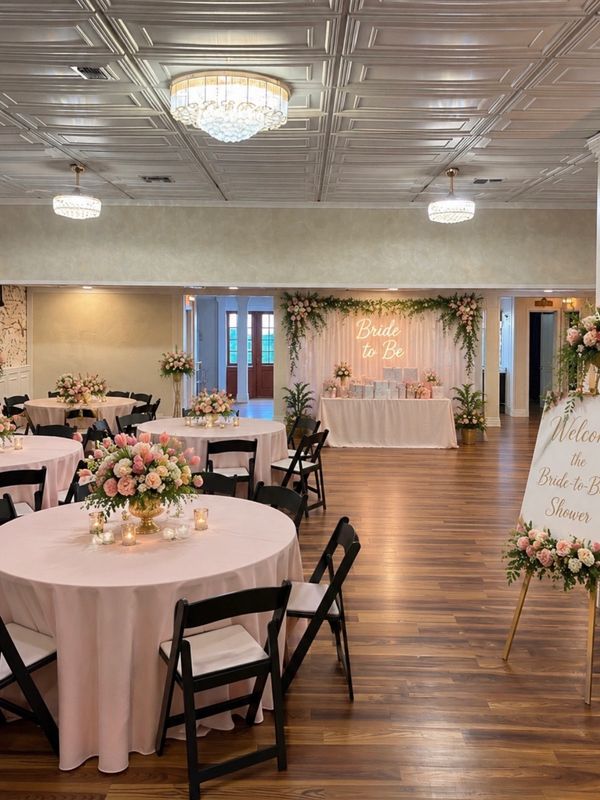 Elegant bridal shower setup with floral decor and soft lighting.