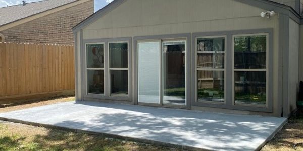 Newly poured concrete patio outside a house.