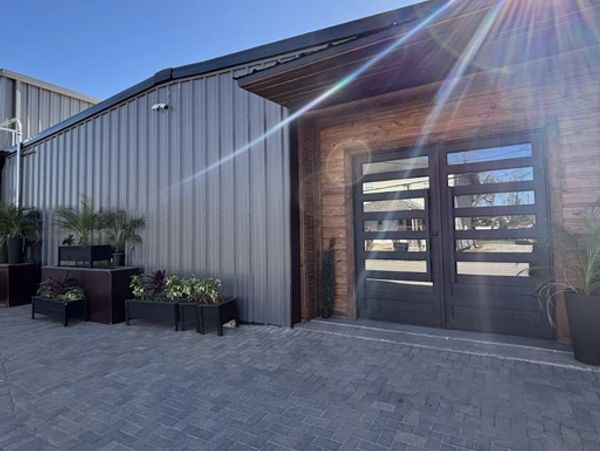Modern industrial building entrance with sunlight flare.