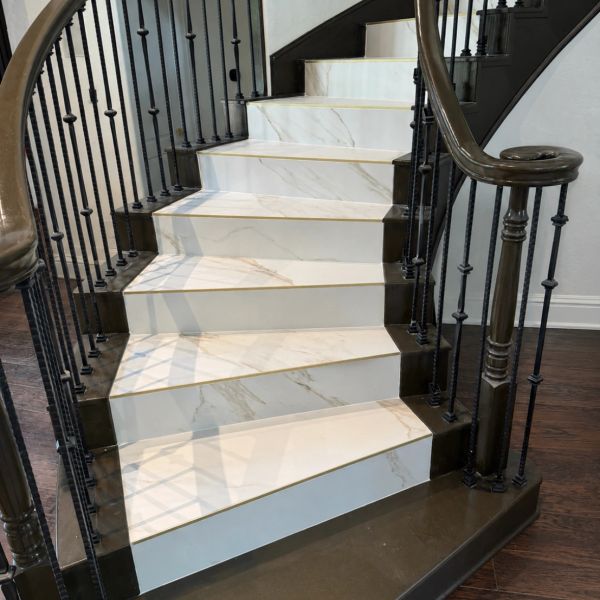Elegant marble staircase with black railing.
