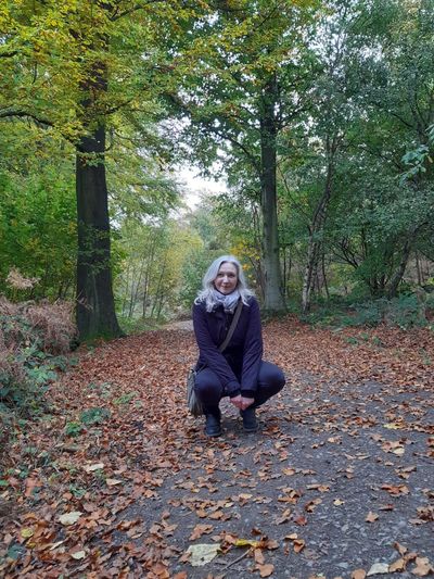 Sound healer Kay Rose of Grounded Sound in the forest enjoying the Autumn leaves