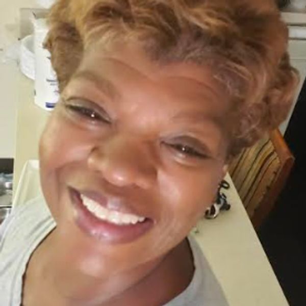 Close-up of a smiling woman with short curly hair.