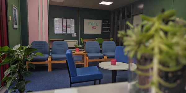 Cozy waiting area with blue chairs and plants.