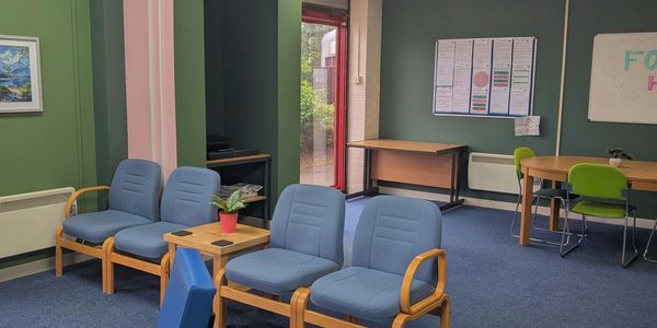 Indoor seating area with blue chairs and a small table.