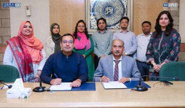 Group photo of professionals signing documents at a formal event.