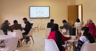 People engaged in group discussions in a modern meeting room.