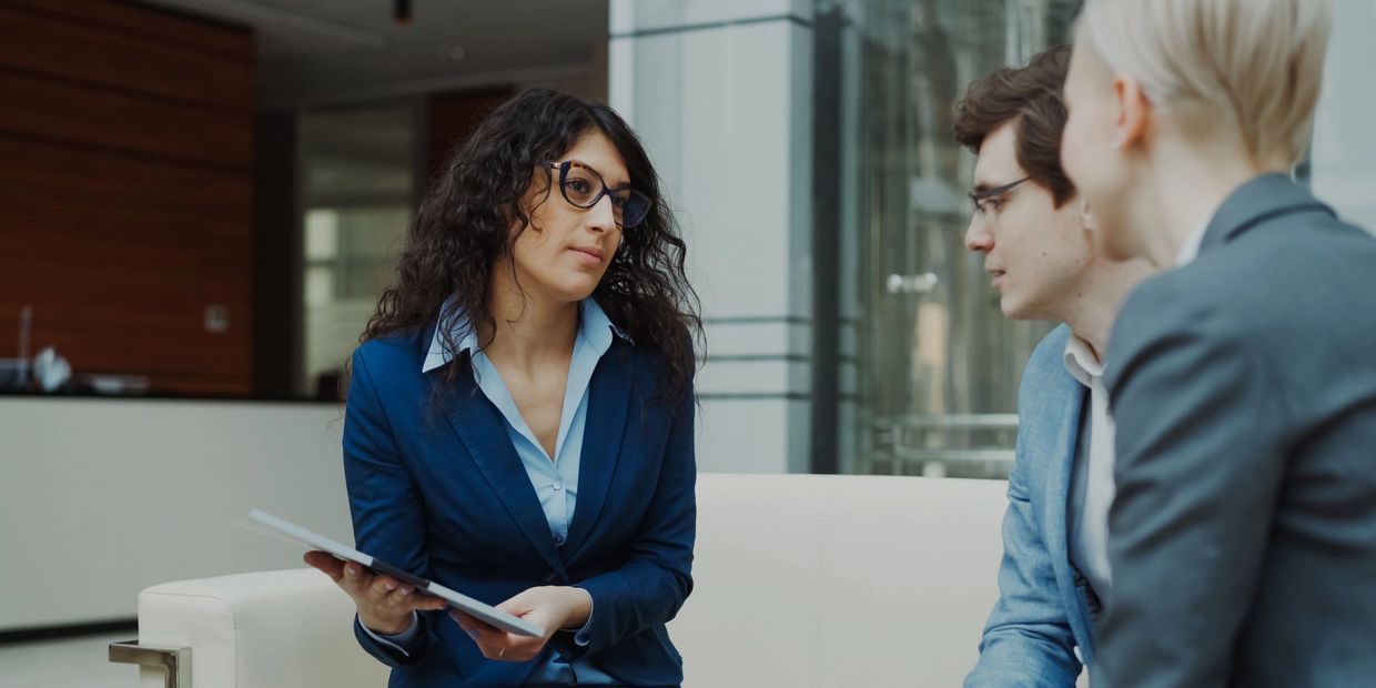 Businesswoman presenting documents to two colleagues.