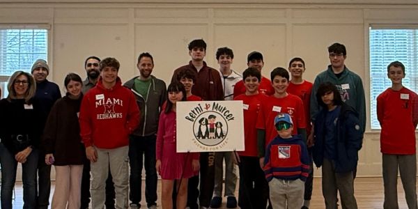 Group of people holding a "Penn &amp; Muter" sign.