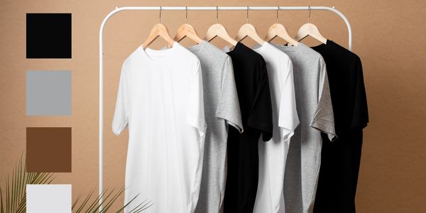 A rack of monochrome t-shirts in black, white, and gray.