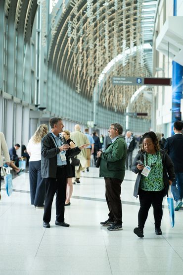 People socializing inside a spacious convention center.