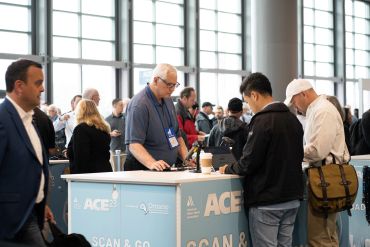 People interacting at an ACE conference booth.