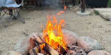 Camping fire pit burning bright with wood.