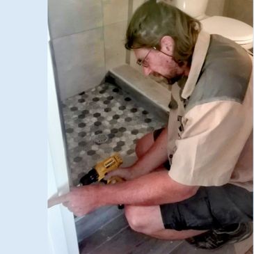 Handyman drilling into wall