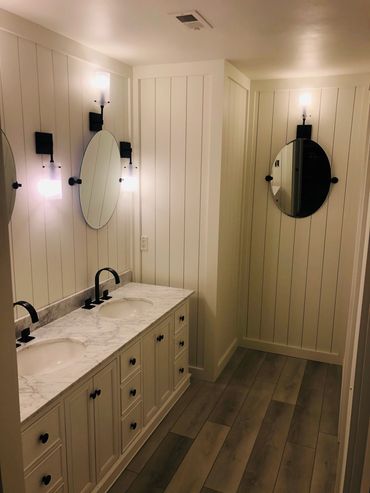 Upscale bathroom with a minimalist bathtub and a backlit designer mirror.