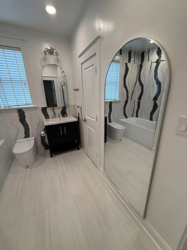 Modern luxury bathroom featuring a sleek soaking tub and large vanity mirror.