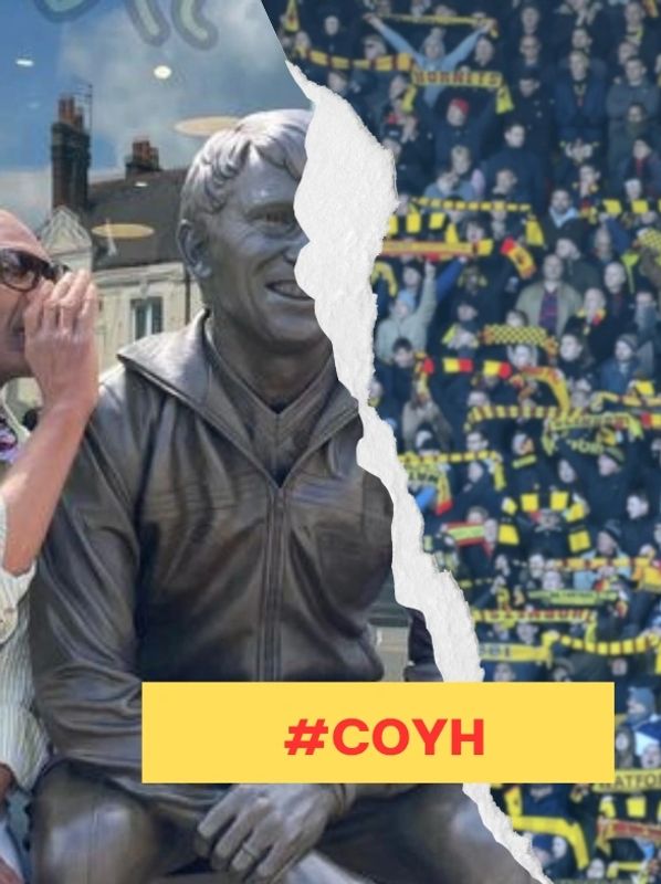 A man whispers to a bronze statue with a crowd of fans behind, #COYH banner.