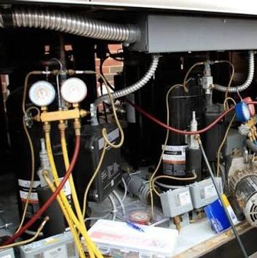 A refrigeration system with gauges and connected hoses.