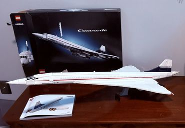 LEGO Airbus Concorde model with box and instruction manual on a wooden table.