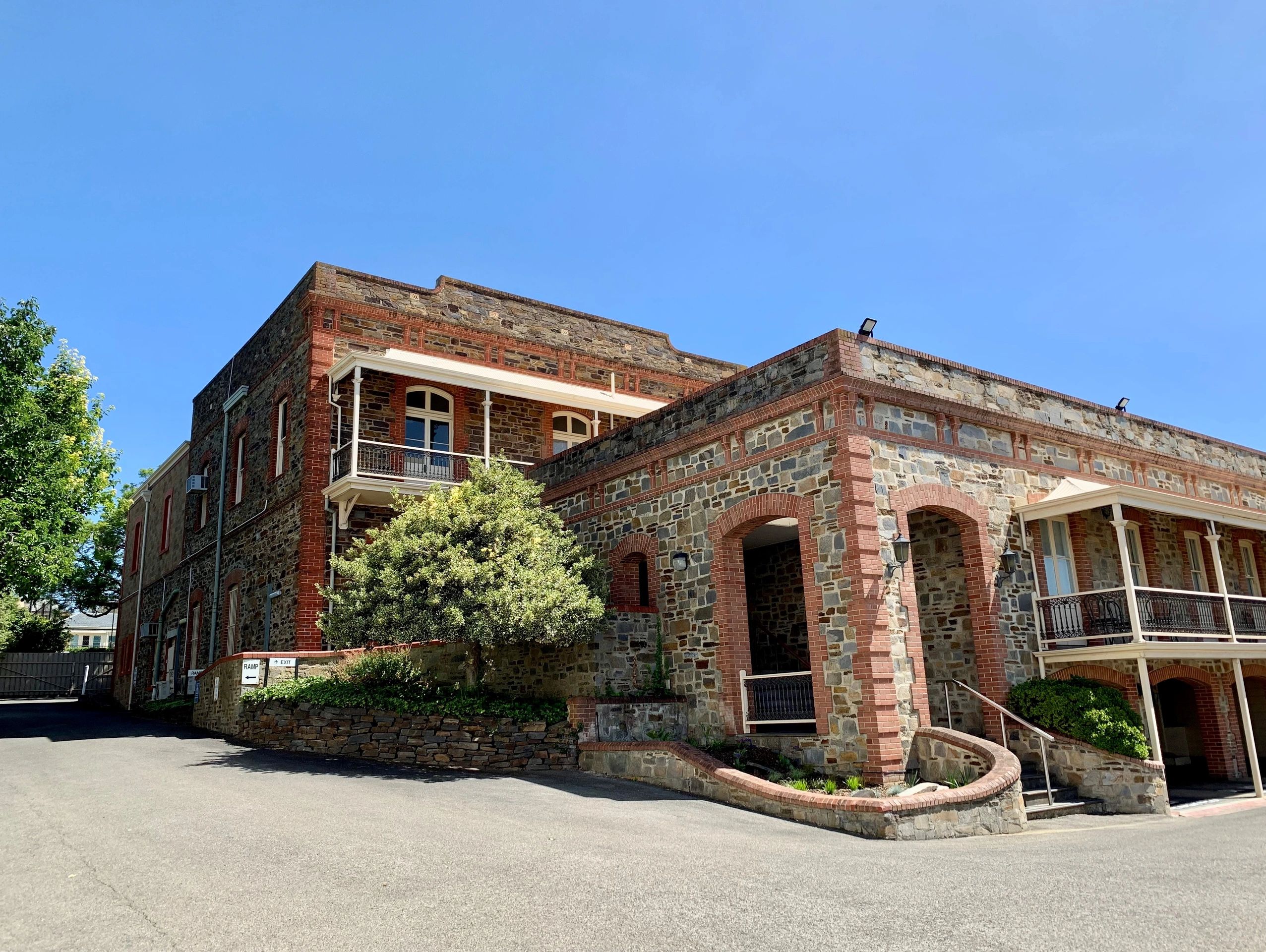 Historic stone building with brick accents and blue sky backdrop.