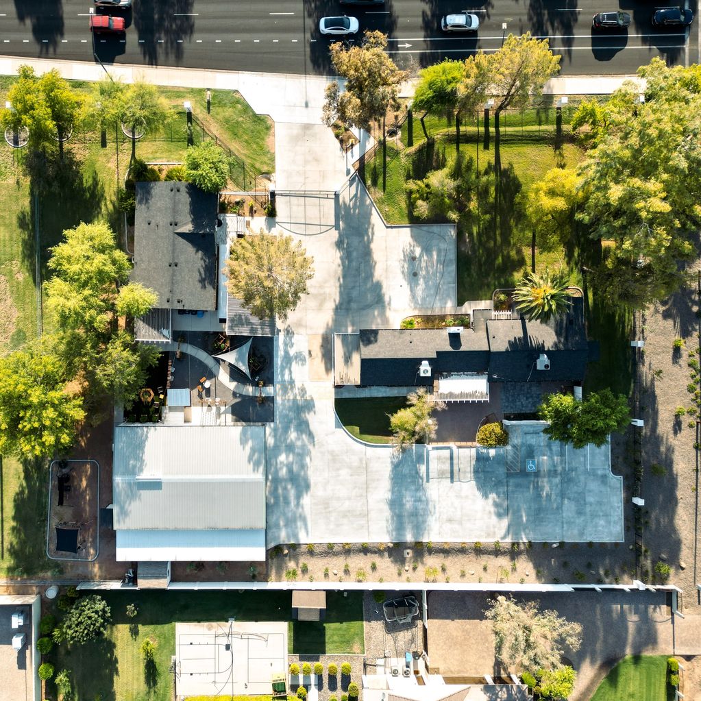 Autism Learning Center Aerial view of site with concrete driveway, parking, playground, and school.
