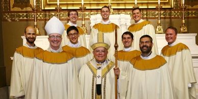 Group of clergy in ceremonial robes posing in a church.