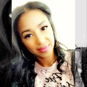 Smiling woman with long dark hair and hoop earrings.