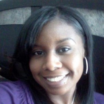Smiling woman with straight hair and hoop earrings.