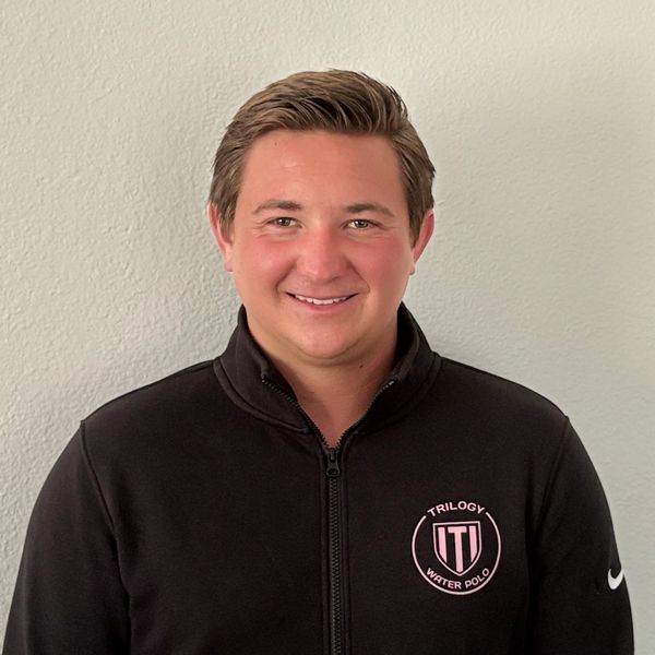 Smiling man in a black Trilogy Water Polo jacket.