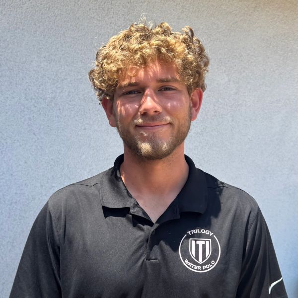 Young man in a Trilogy Water Polo shirt smiling.