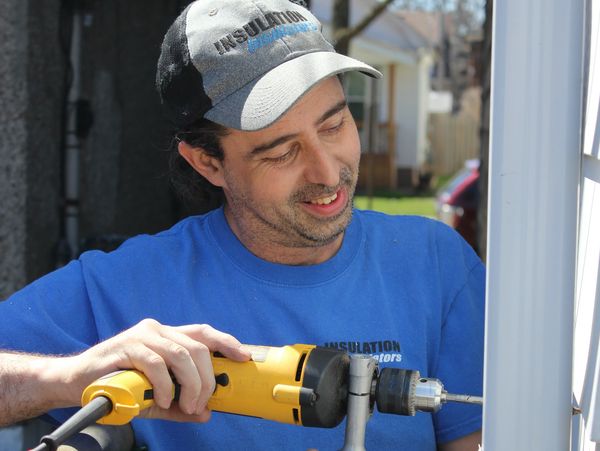 Man using a power drill outdoors.