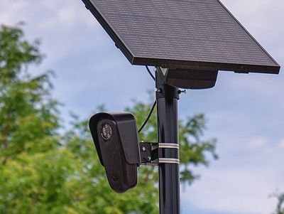 Security camera with solar panel mounted outside.
