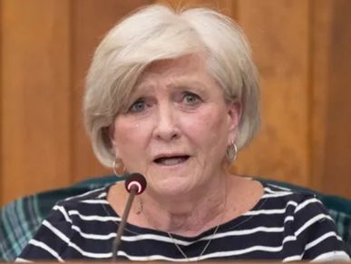 Woman speaking at a microphone.
