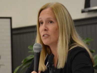 Woman speaking into a microphone.