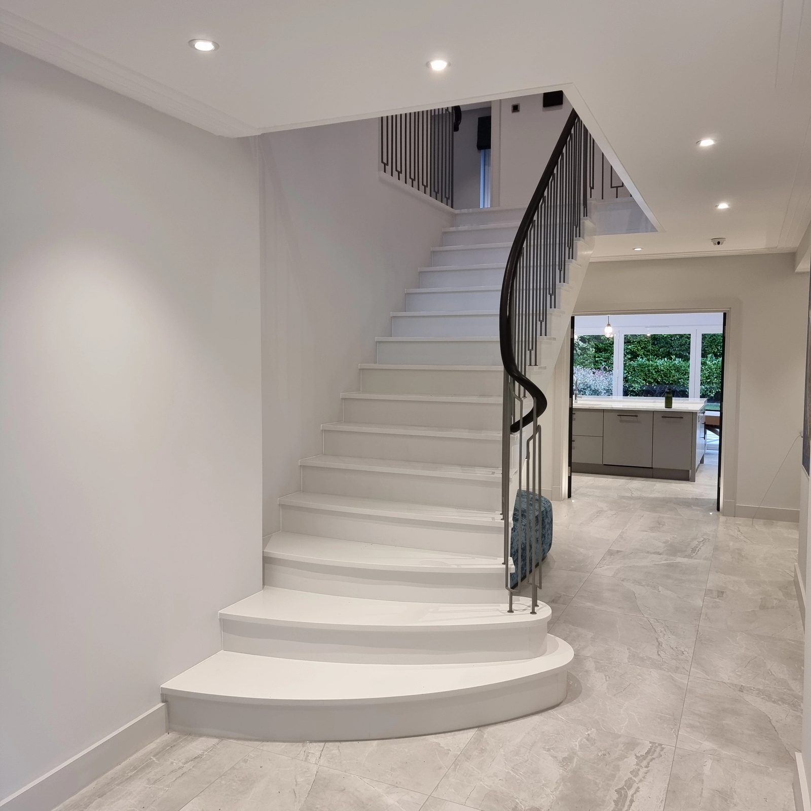 Curved stone staircase with a slim metal balustrade
