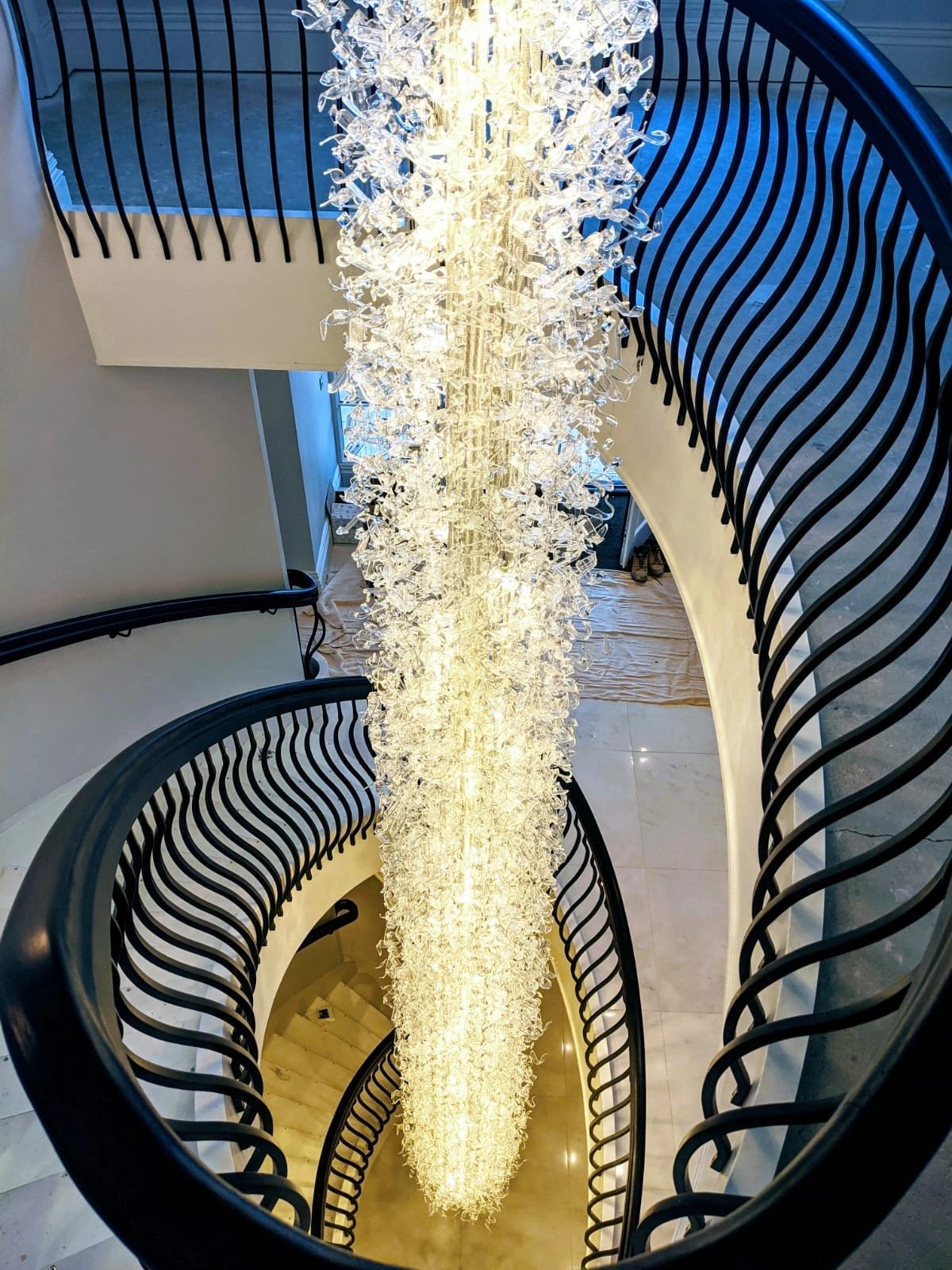 Helical staircase photographed from above around a suspended crystal light feature