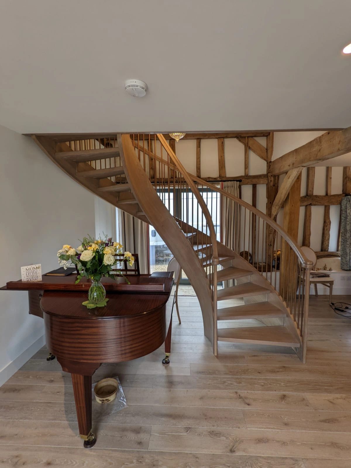 Oak staircase set within an open timber-framed interior