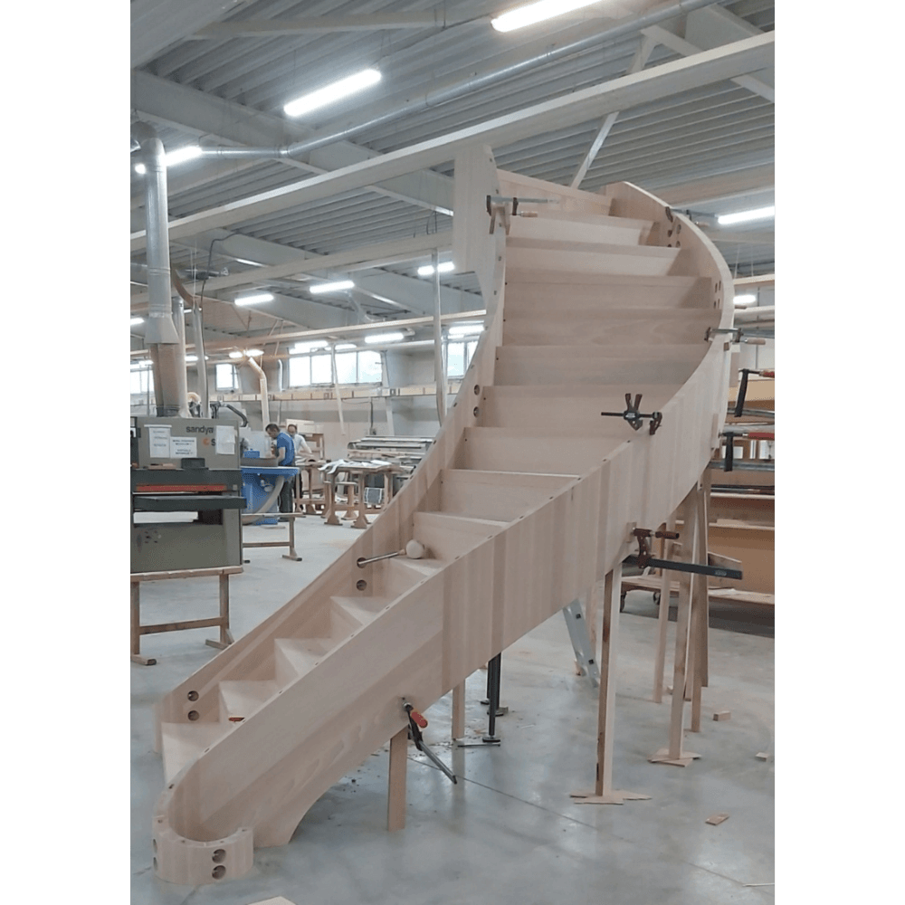 Large curved staircase assembled on the workshop floor before installation