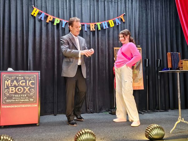 Magician performing birthday magic show.