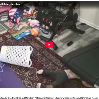 Child trapped beneath treadmill in cluttered room.