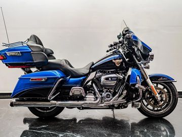 A sleek blue touring motorcycle with chrome details parked indoors.