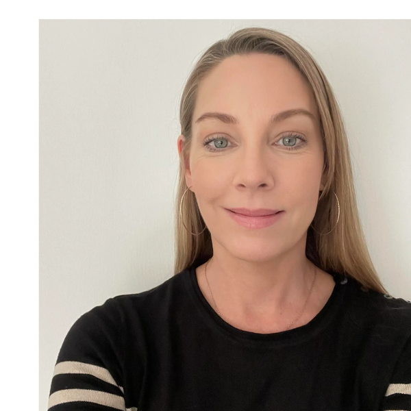Smiling woman with hoop earrings and striped black sweater.