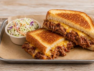 Cheesy pulled beef sandwich with coleslaw.