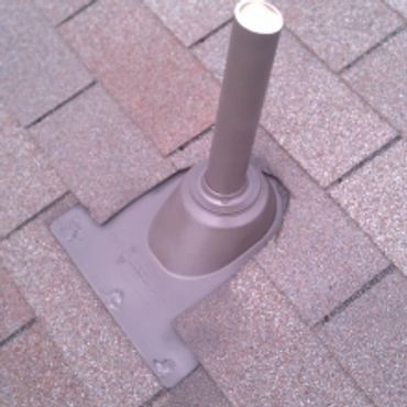 Close-up of a roof vent pipe with flashing on asphalt shingles.