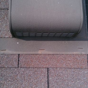 Close-up of a roof vent and shingles with metal flashing.