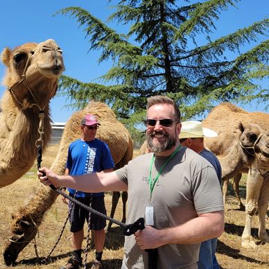 Happy camel leading and posing with a happy camper