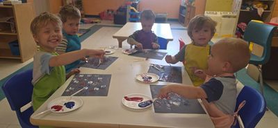 Kids painting together at a table.