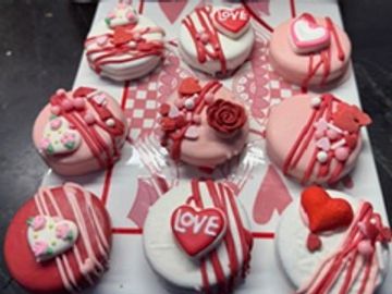 Valentine-themed decorated cupcakes with love and heart designs.