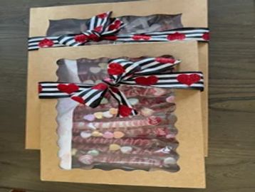 Two gift boxes tied with striped and heart-patterned ribbons containing chocolates.