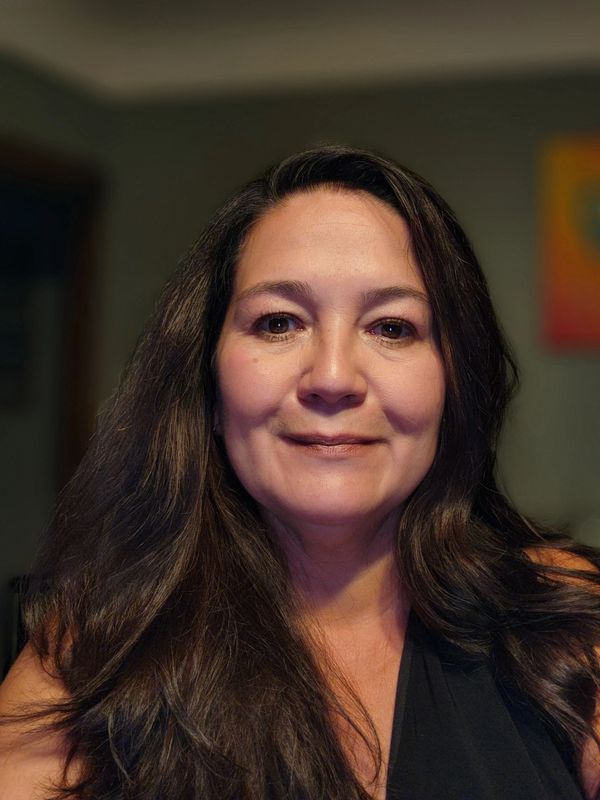 Woman with long dark hair smiling softly at the camera.
